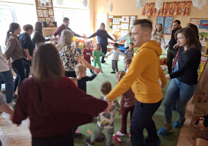 Zdjęcie przedstawia rodziców i dzieci podczas wspólnych zabaw przy muzyce.