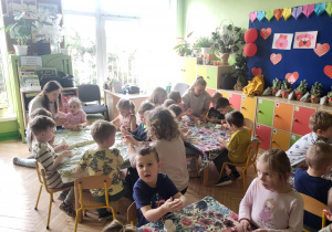 Zdjęcie przedstawia dzieci oraz dwie mamy podczas zabaw ze sztucznym śniegiem.