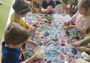 Zdjęcie przedstawia dzieci podczas zabaw ze sztucznym śniegiem.