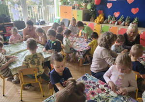 Zdjęcie przedstawia dzieci oraz rodziców podczas zabaw ze sztucznym śniegiem.