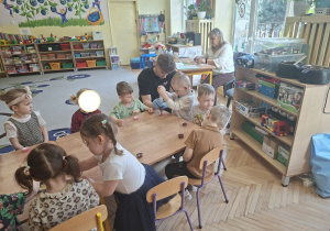 Na tym zdjęciu widać Olka C., który napełnia foremkę płynną czekoladą oraz inne dzieci.