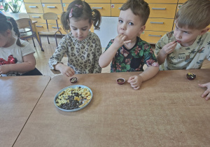 Na tym zdjęciu widać Emmę, Szymona oraz Damianka ozdabiających sowje pralinki.