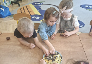 Na tym zdjęciu widać Mikołaja L., Apolonię oraz Lenę T., którzy ozdabiają swoje pralinki.