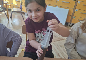 Na tym zdjęciu widać Olę L., która napełnia foremkę płynną czekoladą.