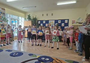 Na tym zdjęciu widać trzy dziewczynki i jednego chłopca z grupy IV recytujących wiersz o witaminach.