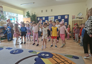 Zdjęcie przedstawia dzieci z grupy IV wykonujące układ taneczny do piosenki.