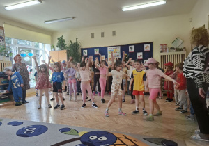 Zdjęcie przedstawia dzieci z grupy IV wykonujące układ taneczny do piosenki.