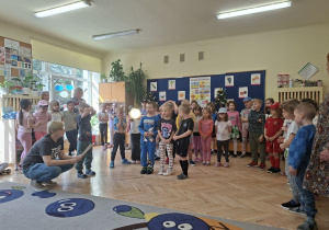 Zdjęcie przedstawia Oskara, Julkę P. oraz Karola recytujących wiersz oraz pozostałe dzieci z grupy III.