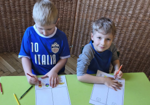 Zdjęcie przedstawia Adasia W. oraz Adasia M. z grupy III podczas wykonywania karty pracy.