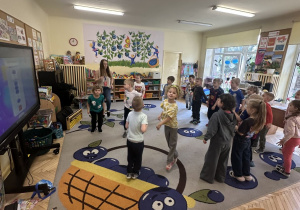 Zdjęcie przedstawia dzieci z grupy III podczas zabawy oraz prowadzącą