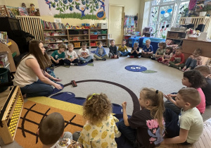 Na tym zdjęciu widać prowadzącą warsztaty, która prezentuje dzieciom z grupy III japońskie liczydło - soroban.
