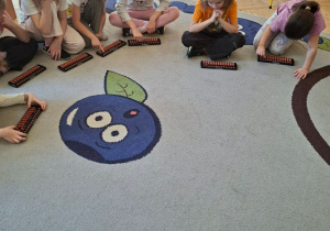 Zdjęcie przedstawia kilkoro dzieci z grupy IV wykonujących działania na japońskich liczydłach.