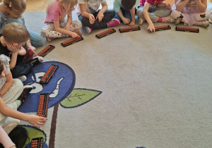 Zdjęcie przedstawia dzieci z grupy IV wykonujące działania na sorobanach.