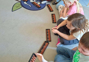 Na tym zdjęciu widac dzieci, które poznają sposób posługiwania się sorobanem.