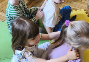 Zdjęcie przedstawia czworo dzieci z grupy III podczas wykonywania masażyku relaksującego.