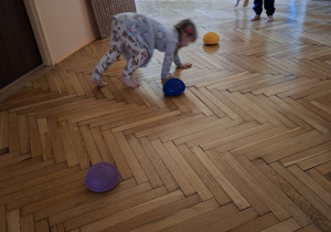 Zdjęcie przedstawia Natalkę z grupy I podczas czworakowania slalomem między jeżykami.