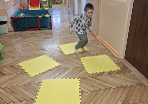 Na tym zdjęciu widać Adasia M. z grupy II wykonującego skoki obunóż z maty na matę.