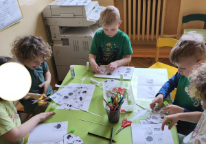 Zdjęcie przedstawia pięcioro dzieci z grupy III wykonujących pracę na temat "Produkty zdrowe i niezdrowe".