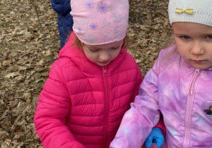 Zdjęcie przedstawia dzieci porządkujące teren parku w pobliżu przedszkola.