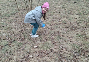 Zdjęcie przedstawia dzieci podczas porządkowania najbliższego terenu wokół przedszkola.