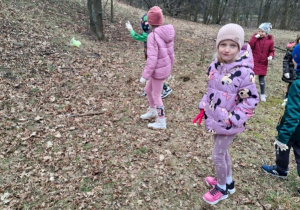 Zdjęcie przedstawia dzieci podczas porządkowania najbliższego terenu wokół przedszkola.