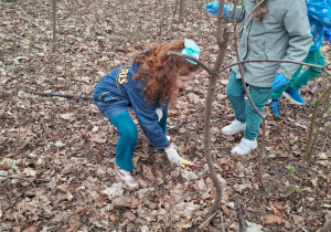 Zdjęcie przedstawia dzieci podczas porządkowania najbliższego terenu wokół przedszkola.