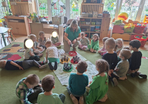 Zdjęcie przedstawia dzieci obserwujące wysiew nasion.