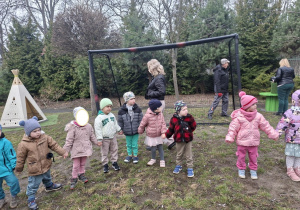 Na tym zdjęciu widać dzieci z grupy I we wspólnym kole w ogrodzie przedszkolnym.