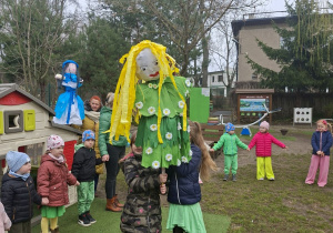 Na tym zdjęciu widać kukłę pani wiosny trzymaną przez dwie dziewczynki z grupy IV.