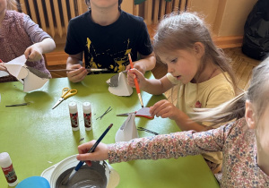 Na tym zdjęciu widać Tymka z grupy IV oraz trzy dziewczynki z grupy III, uczestników projektu, którzy wykonywali pracę plastyczną "Myszki".