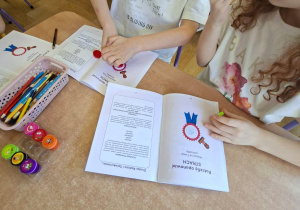 Zdjęcie przedstawia Julka i Mayę, którzy wykonują pracę w kartach pracy.