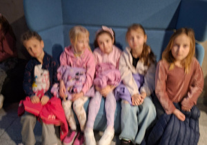 Na tym zdjęciu widać pięć dziewczynek z grupy IV siedzące na kanapie w holu.