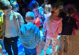 Zdjęcie przedstawia dzieci z grupy III i IV podczas zabaw na dywanie interaktywnym.