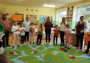 Zdjęcie przedstawia rodziców i dzieci podczas wspólnej zabawy w kole.