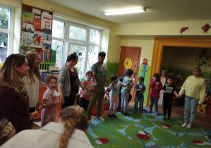 Zdjęcie przedstawia rodziców i dzieci podczas wspólnej zabawy w kole.