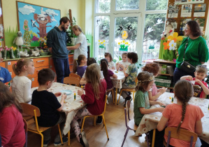 Na tym zdjęciu widać dzieci wykonujących pracę plastyczną oraz kilkoro rodziców.