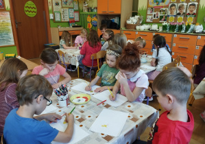 Na tym zdjęcu widać dzieci, które wykonują pracę plastyczną.
