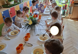 Na tym zdjęciu widać dzieci spożywające świąteczny żurek z jajkiem.
