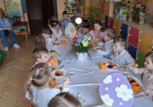 Zdjęcie przedstawia dzieci przy świątecznym stole, spożywające drugie danie.