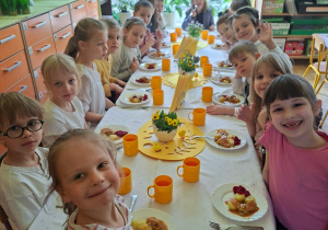 Na tym zdjęciu widać dzieci siedzące przy świątecznym stole, spożywające drugie danie.