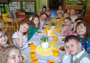 Na tym zdjęciu widać dzieci siedzące przy świątecznym stole, spożywające drugie danie.