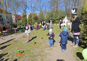 Zdjęcie przedstawia dzieci biorące udział w konkurencji zręcznościowej - przenoszenie jaj na łyżce.