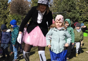 Zdjęcie przedstawia jedną z dziewczynek skaczącą w worku w towarzystwie króliczka.