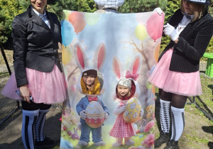 Zdjęcie przedstawia prowadzące w przebraniu króliczków przy fotoramce.