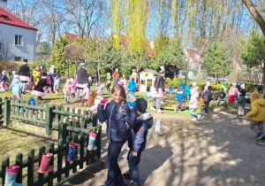 Na tym zdjęciu widać dzieci poszukujące ukrytych w ogrodzie jajek.