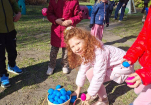 Zdjęcie przedstawia Mayę z koleżankami z koszykami pełnymi jajek zebranych w ogrodzie.