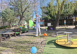 Na tym zdjęciu widać wielkanocnego zajączka zmierzającego w kierunku dzieci.