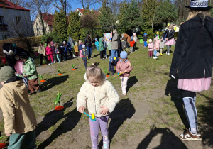Zdjęcie przedstawia Kamilkę i Lenę T. przenoszące jajka na łyżce oraz inne dzieci.