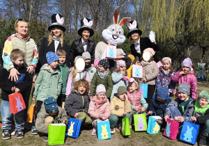 Zdjęcie przedstawia całą grupę z prezentami od wielkanocnego zajączka odnalezionymi w ogrodzie.