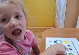 Zdjęcie przedstawia Julę P. z grupy III wykonującą ćwiczenia narządów mowy.